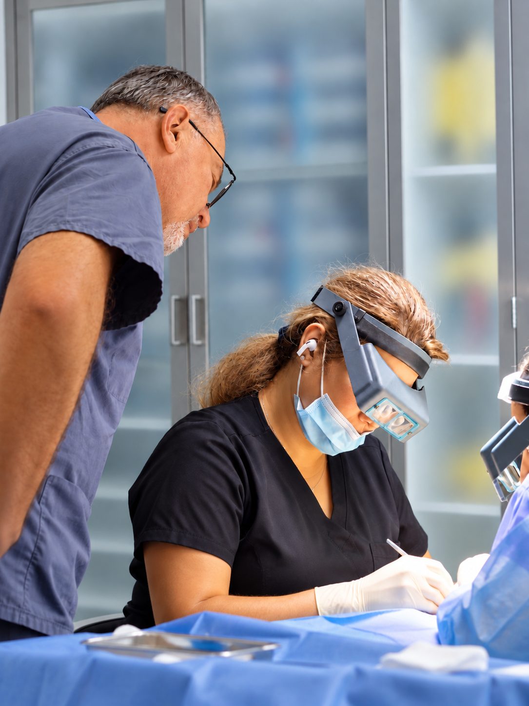 Technician working under magnifying loupes while Dr. Val Prokurat, MD reviews the procedure at Nova Medical New Jersey in Freehold